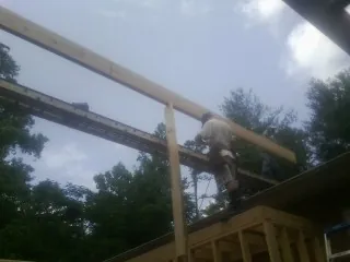 Carpenter setting a ridge beam over a new addition frame — Ice Dam Removal by Roofing Brothers in Moshannon