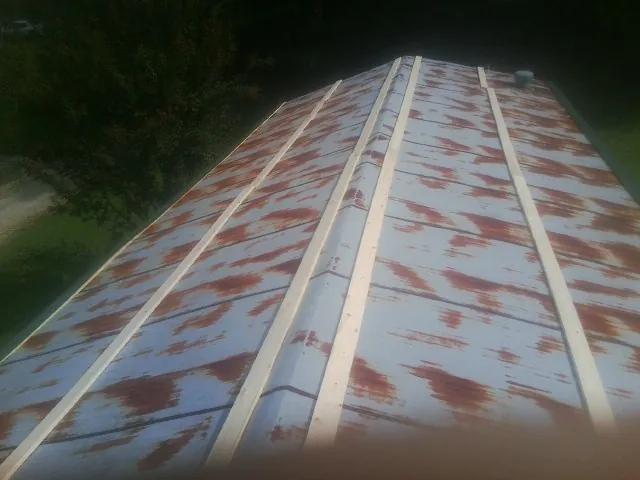 Rusted metal roof panels with new wood purlins before replacement — Storm Damage Roof Repair in Moshannon by Roofing Brothers