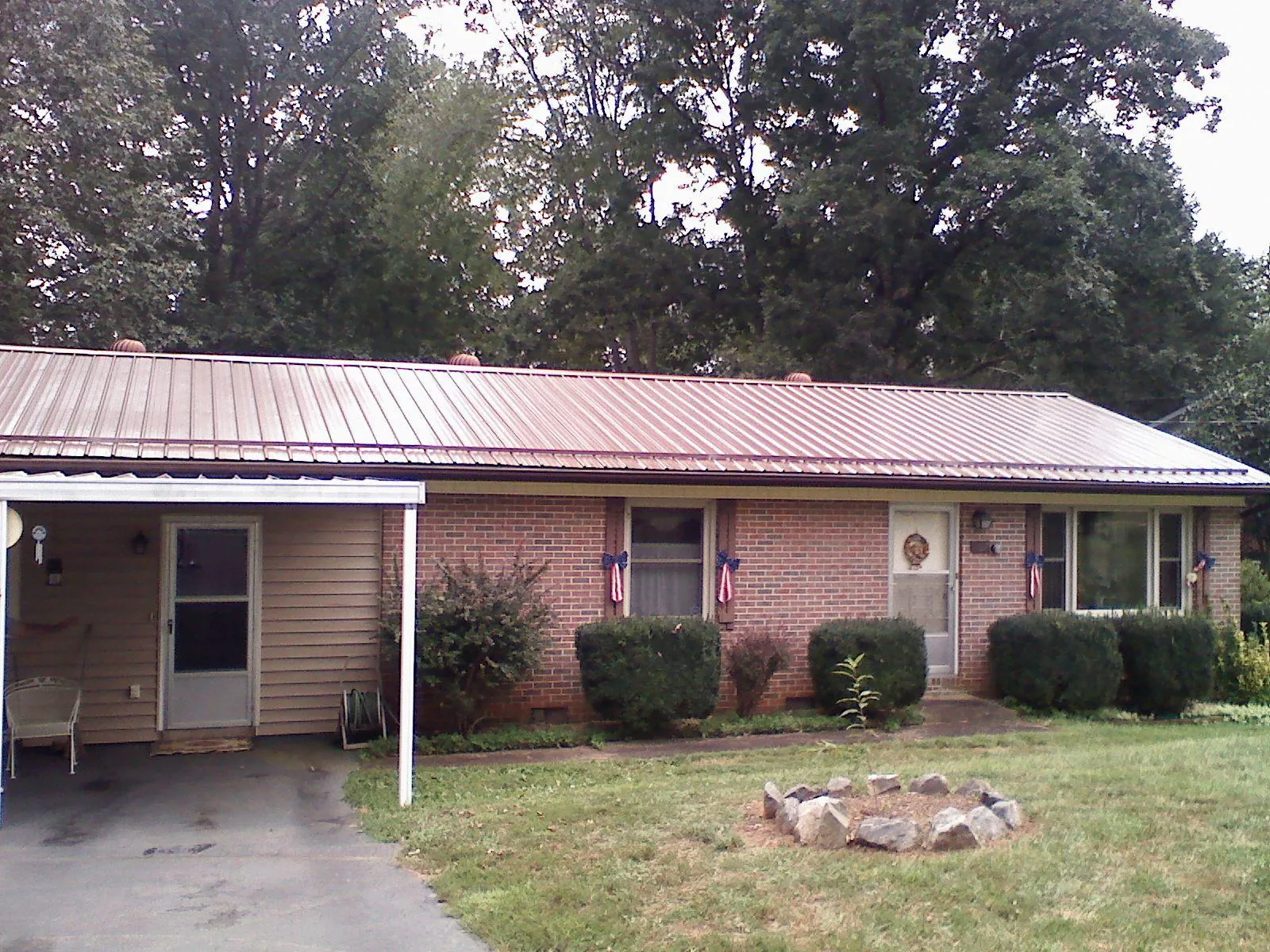 Bronze metal roof and carport on a brick ranch home — Roof Repair work by our crew in Moshannon